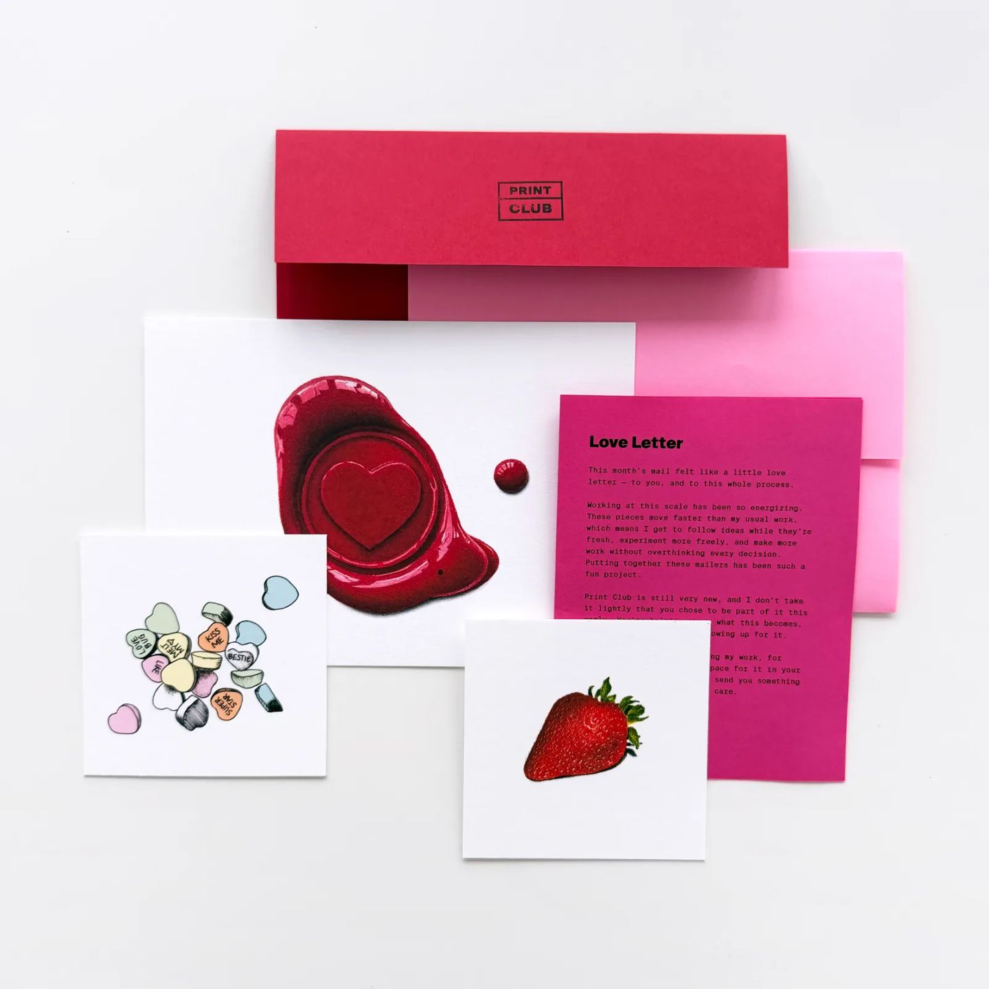 A Print Club mailer flat-lay with prints, note, and envelopes